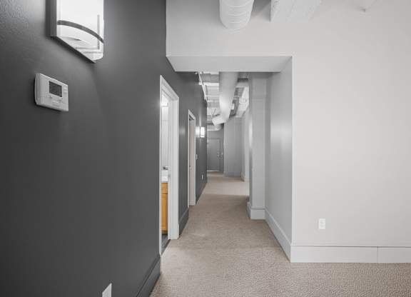 A long hallway with doors on both sides and a light on the wall.