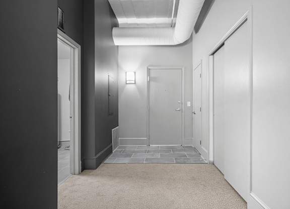 A hallway with doors on both sides and a carpeted floor.