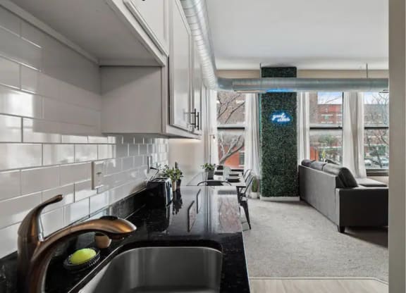 a kitchen and living room with a sink and a window