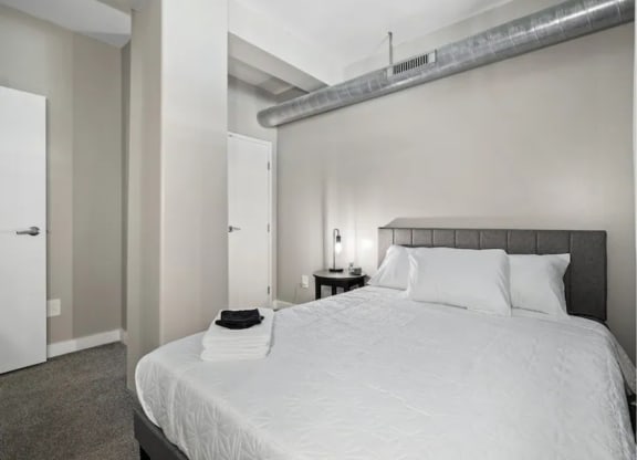 a white bedroom with a large bed and a white closet