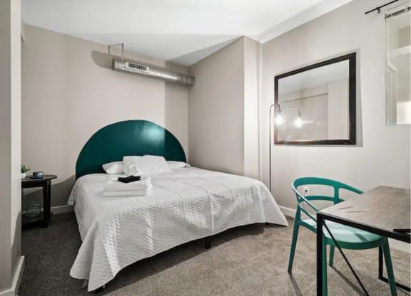 a bedroom with a bed and a table and chairs