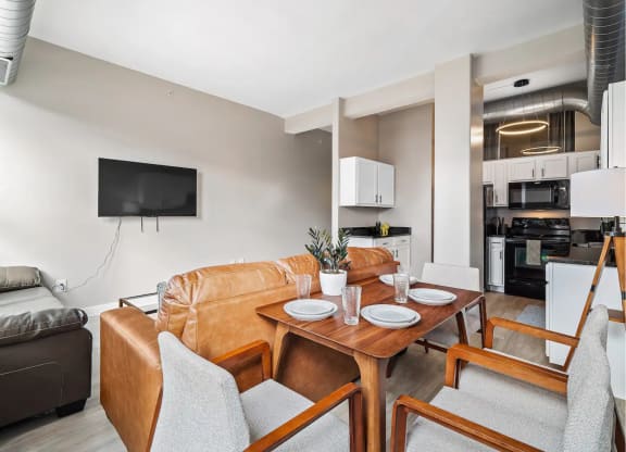 a living room with a leather couch and a wooden table