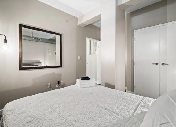 a bedroom with a large bed and a mirror