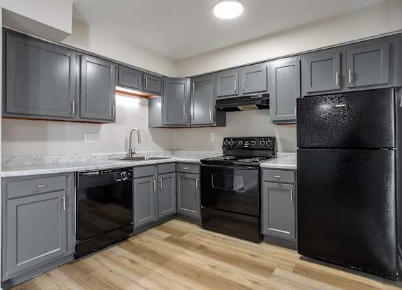A kitchen with black appliances and grey cabinets. at Commons At Waters Edge, Columbus Ohio