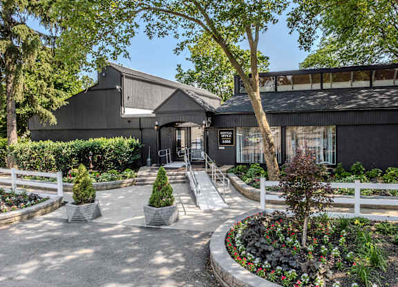A black building with a white fence and a garden in front. at Commons At Waters Edge, Columbus Ohio