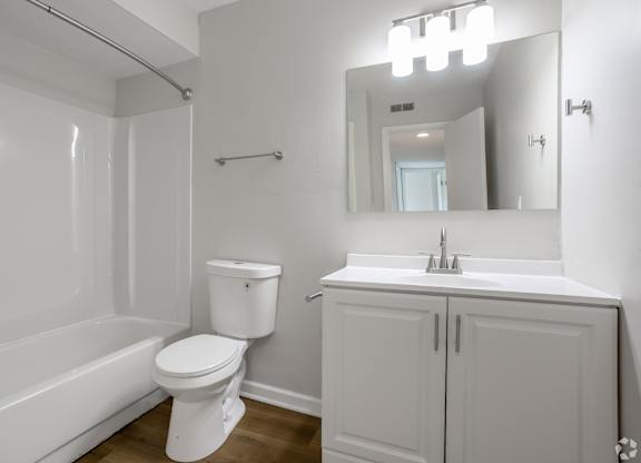 A white bathroom with a toilet, sink, and bathtub. at Commons At Waters Edge, Columbus Ohio