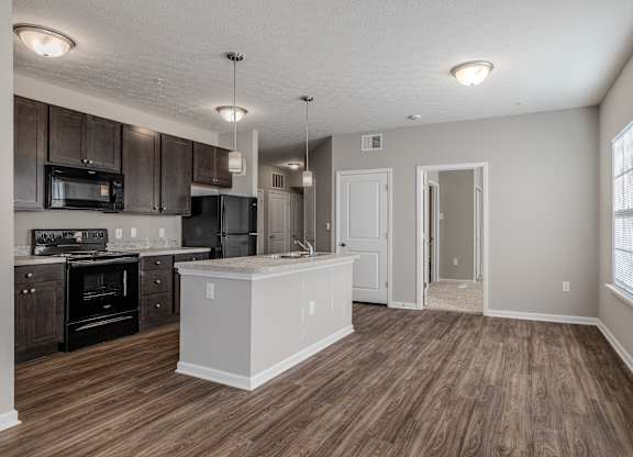A kitchen with dark wood floors at The Residences at Akita Lane, Canal Winchester Ohio