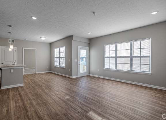 A spacious room with wood flooring and a kitchenette.at The Residences at Akita Lane, Canal Winchester