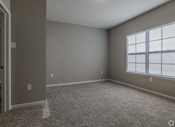 A room with a carpeted floor and a window with blinds.at The Residences at Akita Lane, Ohio