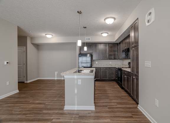 A kitchen with a white island at The Residences at Akita Lane, Canal Winchester, OH 43110