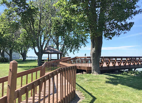 A wooden bridge over a grassy area with trees.