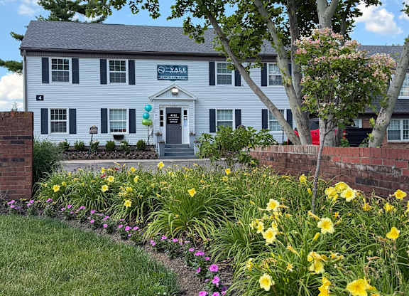 Beautiful flower garden with yellow and purple blooms at The Vale at Walnut Creek Apartments, Columbus, OH 43232