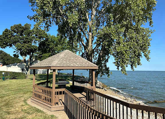 A gazebo sits on a wooden deck overlooking Lake Erie
