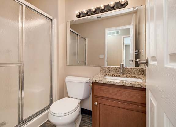 A bathroom with a toilet, sink, and shower.