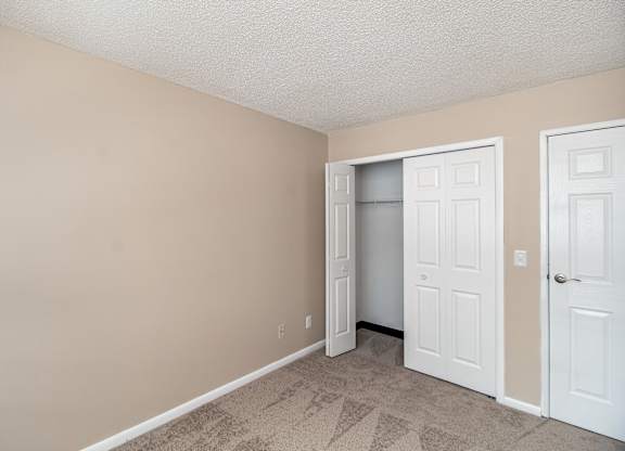 A room with a white door and a white closet door.