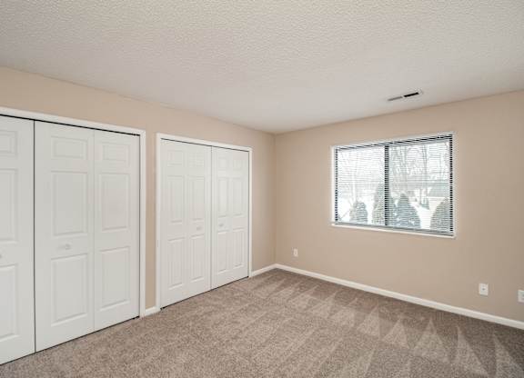 A room with white doors and a carpeted floor.