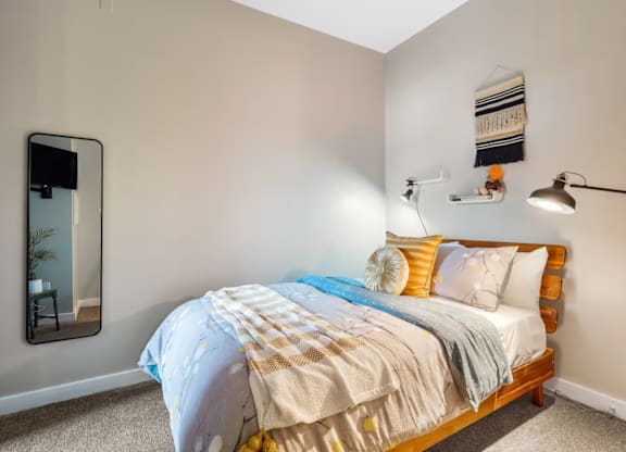 A bedroom with a bed covered in a blue and white comforter.