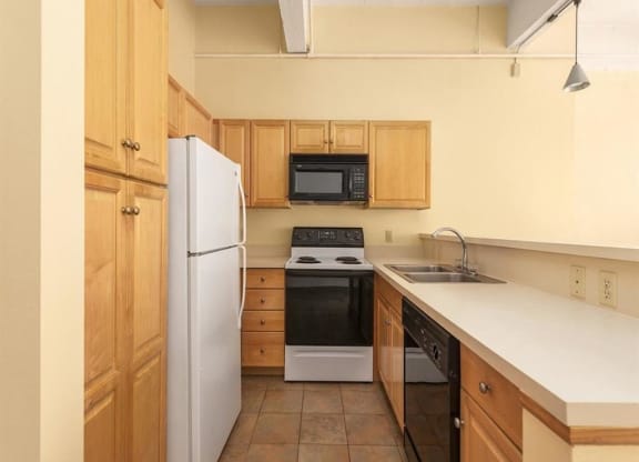 a kitchen with a white counter top and a black and white stove top oven