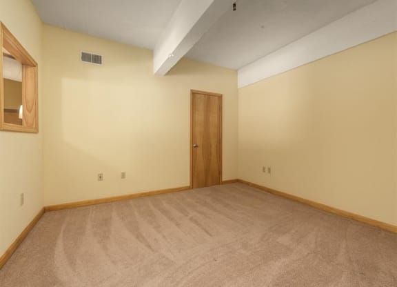 an empty room with a door and a mirror