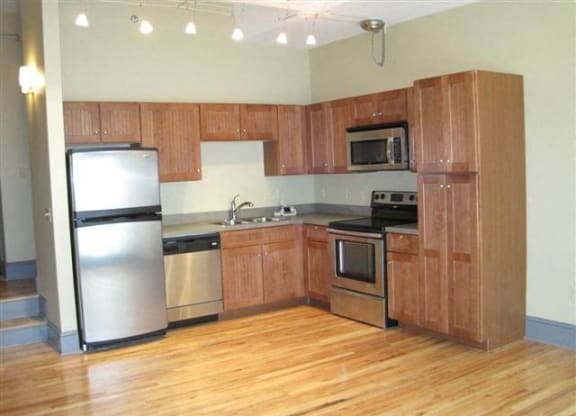 a kitchen with wooden cabinets and stainless steel appliances