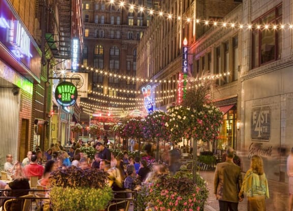 a crowd of people walking down a street at night