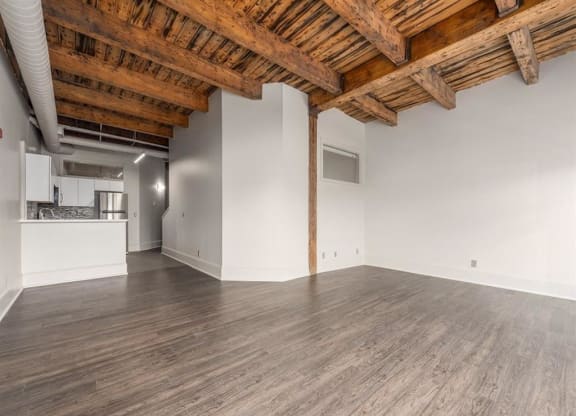 an empty room with white walls and a wooden ceiling