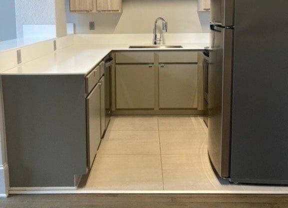 a kitchen with a refrigerator sink and cabinets