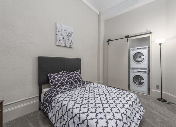 a bedroom with a bed and a washer and dryer