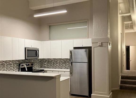 a kitchen with a refrigerator a sink and a microwave