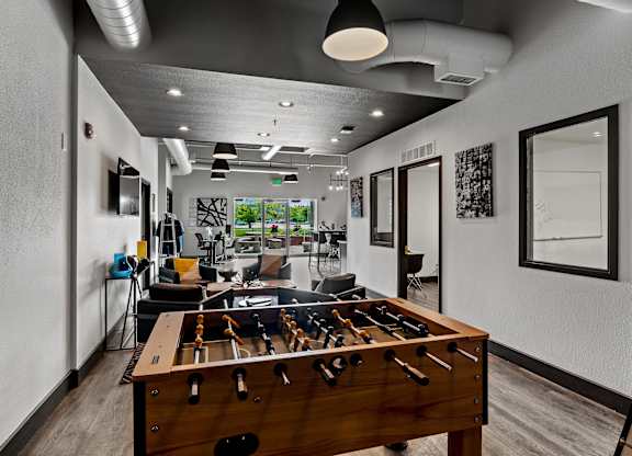 A room with a pool table and a foosball table. at Vivo Toledo Apartments, Toledo, OH, 43607