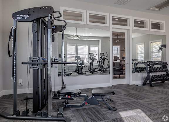 A gym with a variety of equipment including a leg press machine.at The Residences at Akita Lane, Canal Winchester Ohio