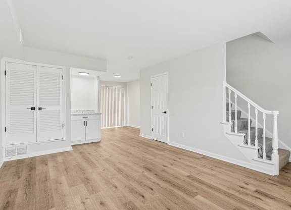 A room with a staircase and a cabinet.