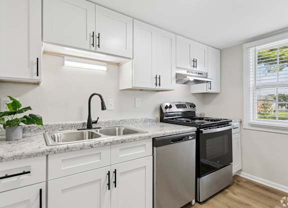 A kitchen with white cabinets and stainless steel appliances.