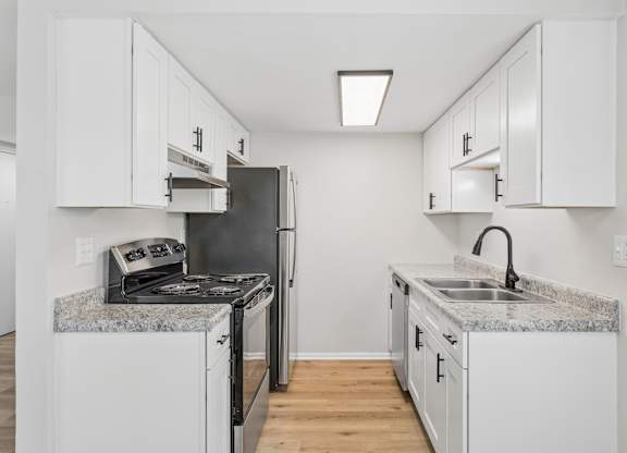 A kitchen with white cabinets and granite countertops.