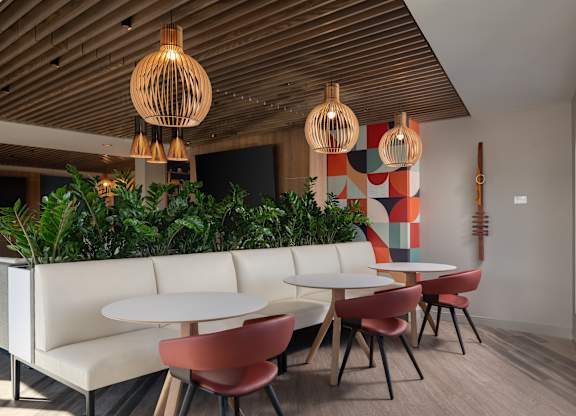 A modern dining area with white tables and chairs at The Park Apartments, Cleveland