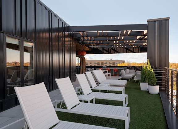A patio with white chairs and a green lawn at The Park Apartments, Cleveland , OH