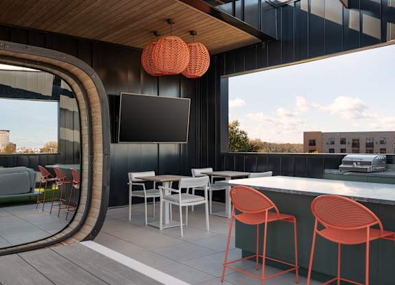 A modern outdoor bar area with a curved glass wall at The Park Apartments, Cleveland , OH