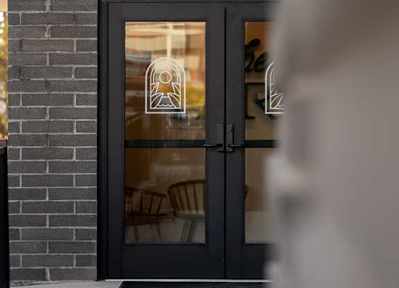 A black door with a glass window is set into a brick wall at The Park Apartments, Cleveland , OH