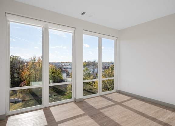A room with a large window overlooking a cityscape at The Park Apartments, Ohio