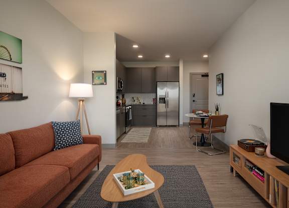 A living room with a couch, a coffee table, and a television at The Park Apartments, Cleveland