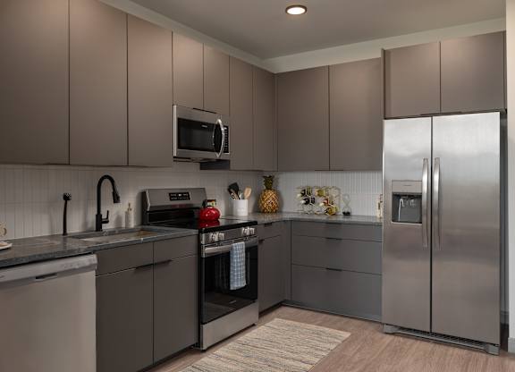 A modern kitchen with a stainless steel refrigerator and a microwave above the stove at The Park Apartments, Ohio