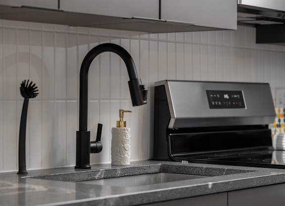 A modern kitchen sink with a black faucet and soap holder at The Park Apartments, Ohio, 44113