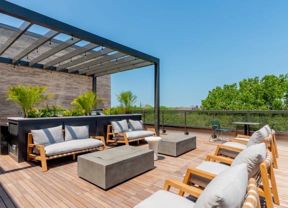 a rooftop deck with couches and a fire pit at TREO Apartments, Cleveland, 44116