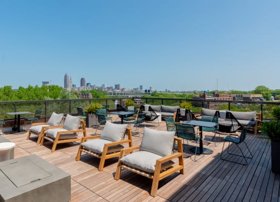 an outdoor deck with lounge chairs and a fire pit with a view of Cleveland TREO Apartments, Cleveland