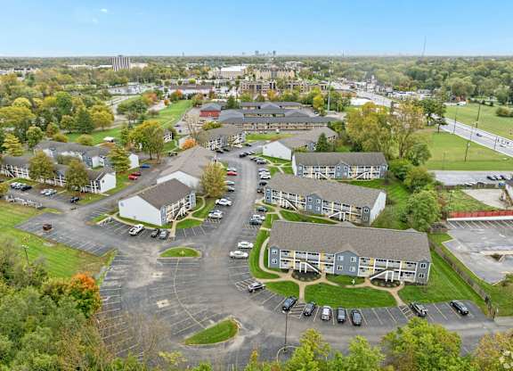 A parking lot is surrounded by apartment buildings.