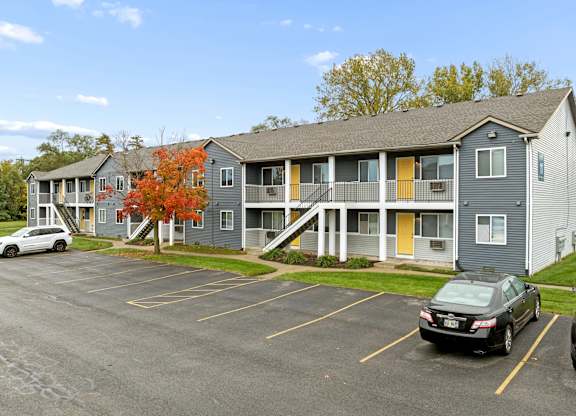 A parking lot with cars and a building in the background.