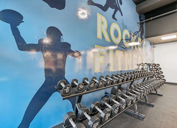 A gym with a wall mural of a football player and the words