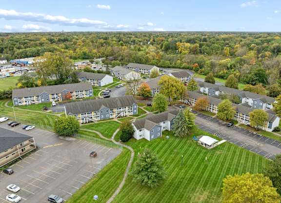 A parking lot is in the foreground of a residential area.