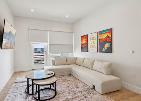 A living room with a couch, coffee table, and pictures on the wall.