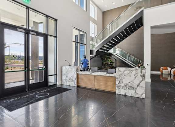 A reception area with a marble counter and a staircase.